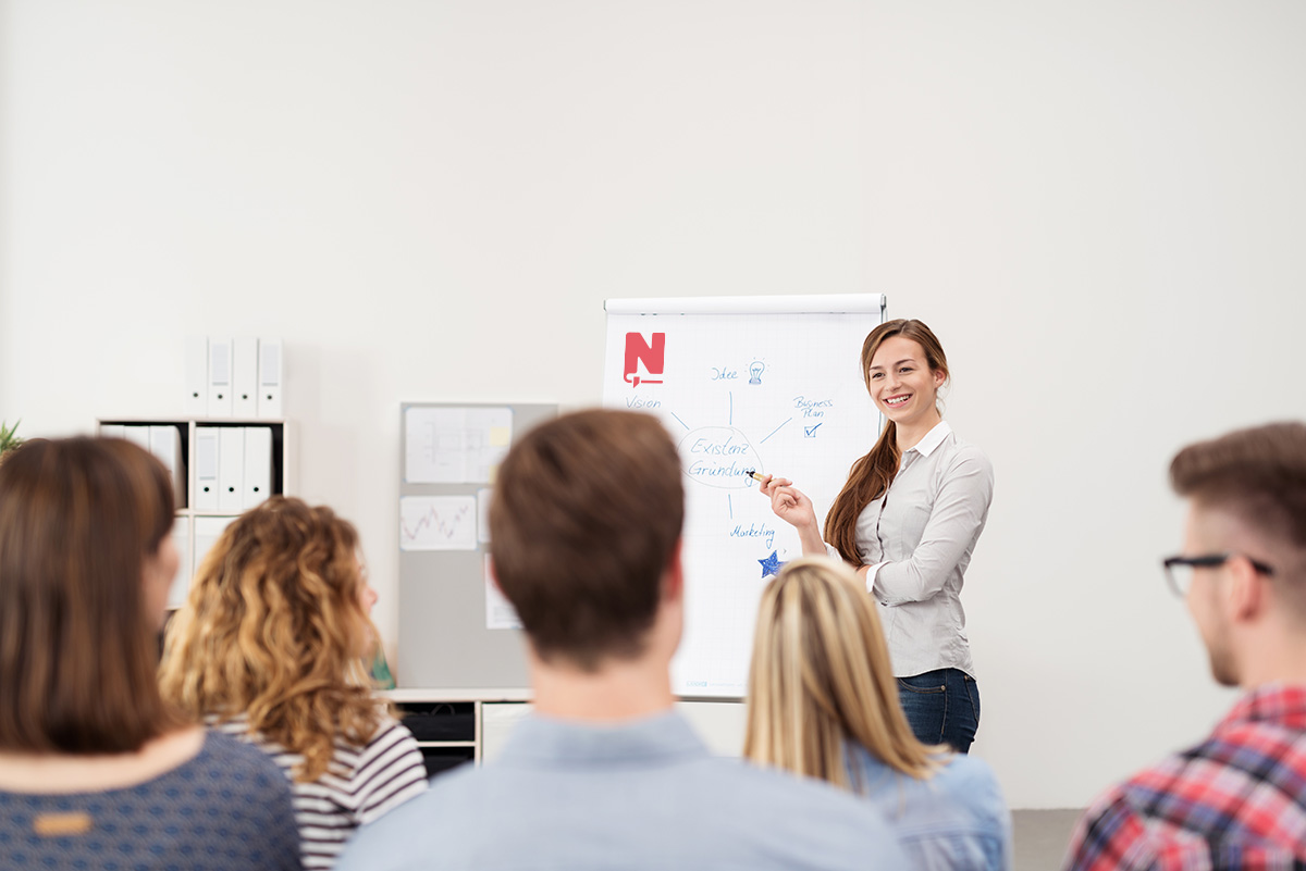 Vrouw geeft een presentatie aan een groep mensen.
